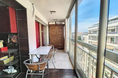 a balcony with a table and chairs and a window at HENRI CAMILLE REAL ESTATE - Kent - Huge 2 bedrooms appt - 5 min Croisette in Cannes