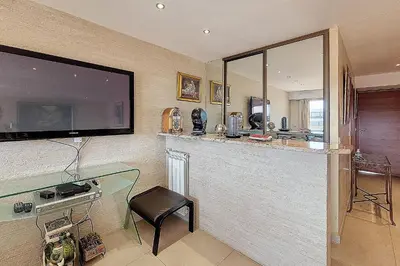 a kitchen with a bar with a tv on the wall at HENRI CAMILLE REAL ESTATE - Kent - Huge 2 bedrooms appt - 5 min Croisette in Cannes