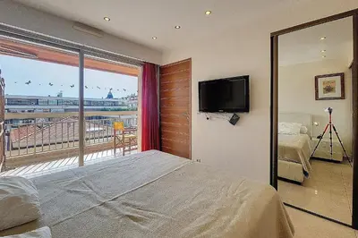 a bedroom with a bed and a balcony with a television at HENRI CAMILLE REAL ESTATE - Kent - Huge 2 bedrooms appt - 5 min Croisette in Cannes