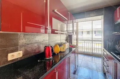 a kitchen with red cabinets and a counter top at HENRI CAMILLE REAL ESTATE - Kent - Huge 2 bedrooms appt - 5 min Croisette in Cannes