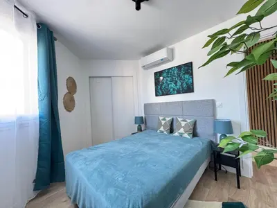 a bedroom with a bed with a blue comforter at Les Venitiennes in Cannes