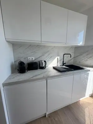 a kitchen counter with white cabinets and a sink at Les Venitiennes in Cannes