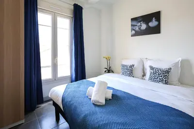 a bedroom with a bed with a towel on it at Cannes Sun, appart'hôtels in Cannes