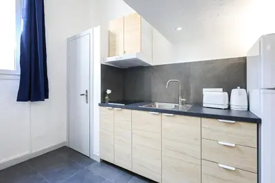 a white bathroom with a shower and a sink at Cannes Sun, appart'hôtels in Cannes