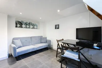 a living room with a couch and a television at Cannes Sun, appart'hôtels in Cannes