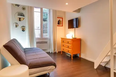 a living room with a couch and a television at Cannes centre Cosy appartement avec mezzanine in Cannes