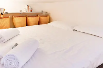 a bedroom with two beds with white sheets and towels at Cannes centre Cosy appartement avec mezzanine in Cannes