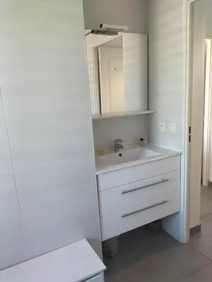 a white bathroom with a sink and a mirror at suite unique in Cannes