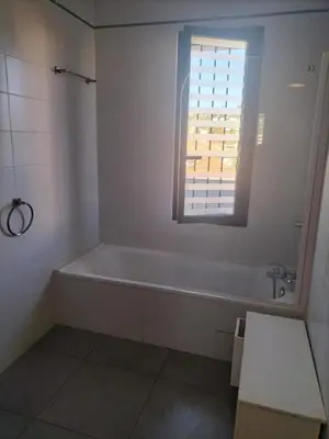 a white bathroom with a tub and a window at suite unique in Cannes
