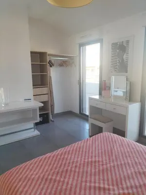 a bedroom with a bed and a desk and a door at suite unique in Cannes