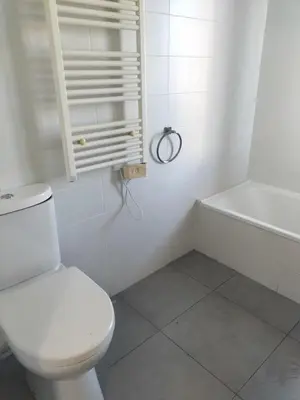 a white bathroom with a toilet and a bath tub at suite unique in Cannes