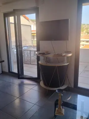 a room with a kitchen with a table and sliding glass doors at suite unique in Cannes