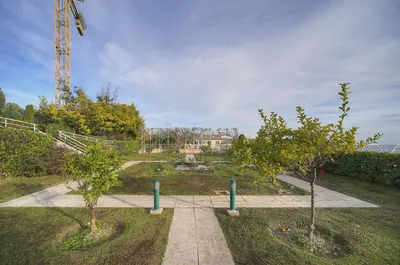 two trees in a park with a crane in the background at Auré-Parking-Piscine-Terrasse-VCA in Cannes