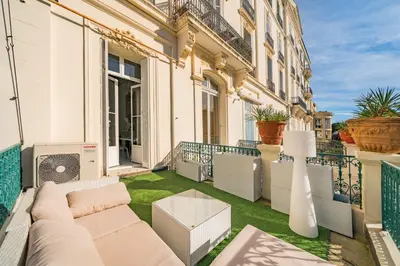 a patio with a couch and grass on a balcony at Prestige Cannes Alexandre III Terrace 2bdr by B'Your Home in Cannes