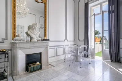 a living room with a fireplace and a table at Prestige Cannes Alexandre III Terrace 2bdr by B'Your Home in Cannes