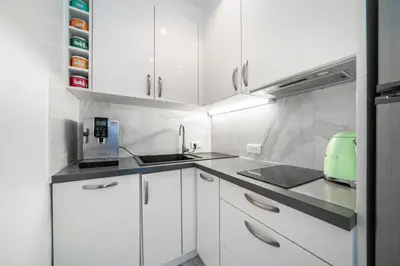 a white kitchen with white cabinets and a green appliance at Prestige Cannes Alexandre III Terrace 2bdr by B'Your Home in Cannes