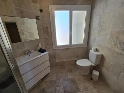 a bathroom with a toilet and a sink and a window at Superbe Appartement Familial in Cannes
