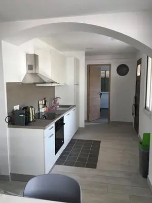 a kitchen with white appliances and an archway at Superbe Appartement Familial in Cannes