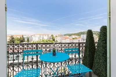 a table and chairs on a balcony with a view at Florella Jean Jaures Apartment in Cannes