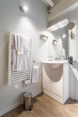 a white bathroom with a sink and a mirror at Florella Jean Jaures Apartment in Cannes