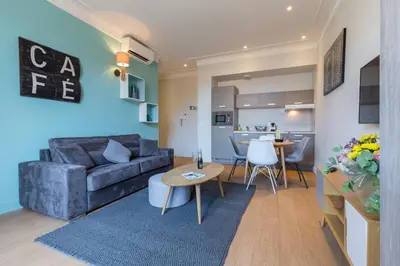 a living room with a couch and a table at Florella Jean Jaures Apartment in Cannes