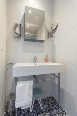 a bathroom with a white sink and a mirror at Florella Jean Jaures Apartment in Cannes