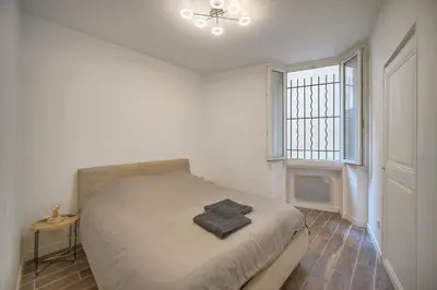 a white bedroom with a bed and a window at Cannes hyper centre quartier historique du suquet -palais-croisette in Cannes