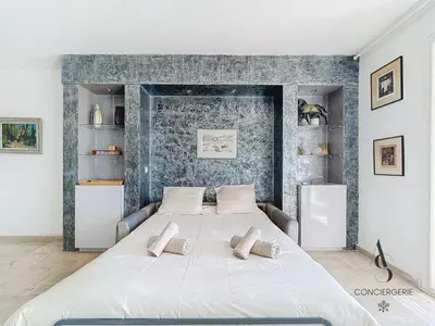 a bedroom with a large white bed with two pillows at L'Alexandra - 4 pers - Parking - Aperçu mer in Cannes