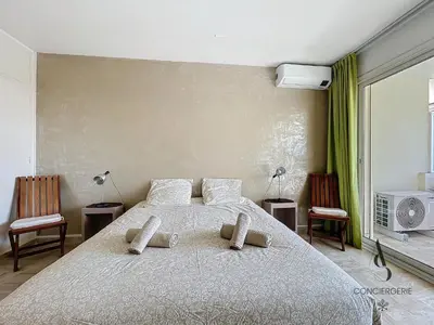 a bedroom with a large bed with two chairs at L'Alexandra - 4 pers - Parking - Aperçu mer in Cannes