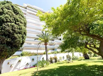 a large white building with trees in front of it at L'Alexandra - 4 pers - Parking - Aperçu mer in Cannes