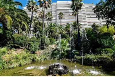 a fountain in a garden in front of a building at L'Alexandra - 4 pers - Parking - Aperçu mer in Cannes