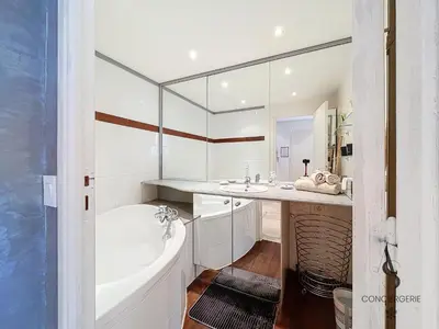 a white bathroom with a tub and a sink at L'Alexandra - 4 pers - Parking - Aperçu mer in Cannes
