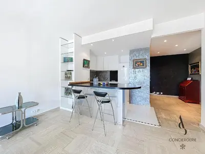 a kitchen with a counter and stools in a room at L'Alexandra - 4 pers - Parking - Aperçu mer in Cannes