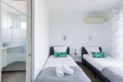 two beds in a small room with a mirror at Diplomate - 2 chambres, 15mn du Palais, charmant, balcon, clim in Cannes