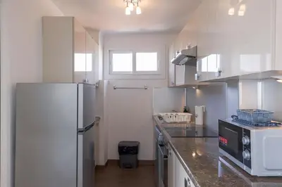 a kitchen with white cabinets and a refrigerator at Diplomate - 2 chambres, 15mn du Palais, charmant, balcon, clim in Cannes