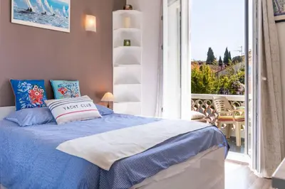 a bedroom with a bed with a view of a balcony at Les voiles des Régates, à 5 minutes du centre à pied, 15 minutes de la mer in Cannes
