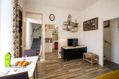 a living room with a table and a desk at Les voiles des Régates, à 5 minutes du centre à pied, 15 minutes de la mer in Cannes