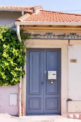 a blue door on the side of a house at Les voiles des Régates, à 5 minutes du centre à pied, 15 minutes de la mer in Cannes