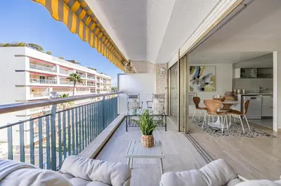 a balcony with a couch and a table on a building at PALM BEACH, sea view apartment, 100m from beaches in Cannes
