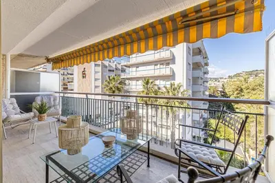 an apartment balcony with a glass table and chairs at PALM BEACH, sea view apartment, 100m from beaches in Cannes