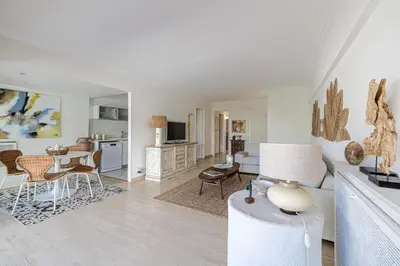 a white living room with a table and chairs at PALM BEACH, sea view apartment, 100m from beaches in Cannes