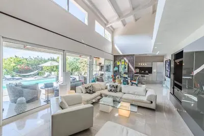 a living room with white furniture and a large window at Diane By Terrys Homes in Cannes