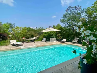 a swimming pool with a hammock and an umbrella at Diane By Terrys Homes in Cannes