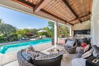 an outdoor patio with wicker furniture and a swimming pool at Diane By Terrys Homes in Cannes