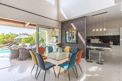 a dining room with a glass table and chairs at Diane By Terrys Homes in Cannes