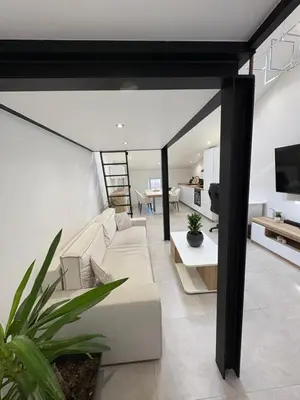 a living room with a white couch and a tv at Le Baptiste in Cannes