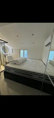 a large bed in a room with a glass wall at Le Baptiste in Cannes