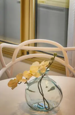 a glass vase with flowers in it sitting on a table at Palace - Ultra center - 2 min sea - VCA in Cannes