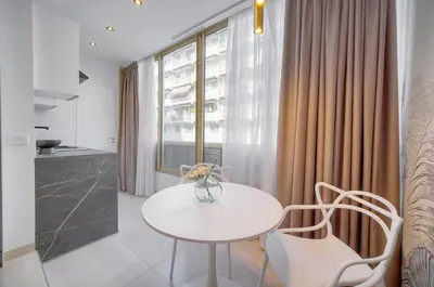 a white table and chairs in a room with a window at Palace - Ultra center - 2 min sea - VCA in Cannes