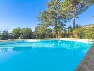 a large swimming pool with trees in the background at Le Cozy by Winsome Destination in Cannes